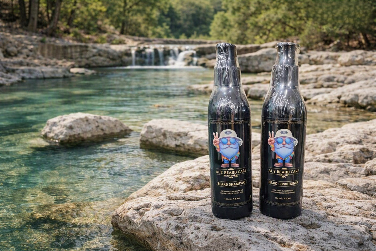 Two bottles of Al's Beard Care Beard Shampoo and Beard Conditioner standing on rocks in a natural outdoor stream setting with a waterfall in the background.